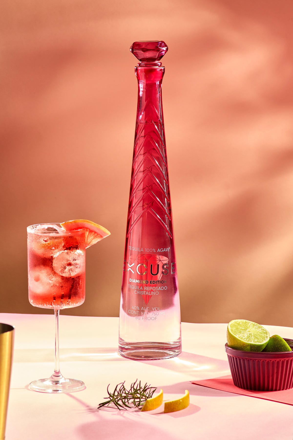 Excuse Tequila Diamond Top Edition poured over ice beside the bottle
